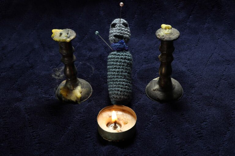 Revenge - Making Voodoo ritual by poking needles in knitting yarn dummy. Dark side of curse ceremony.